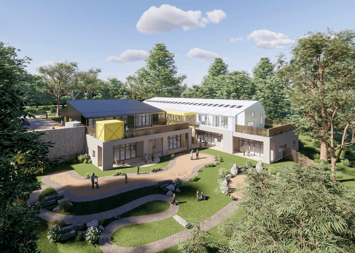 Modern two-story building with yellow accents surrounded by trees and a landscaped garden.